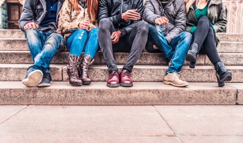 <p>Group of people sitting on a staircase outdoors, close up on low section body - Multiracial friends talking and having fun on a meeting outdoors</p>