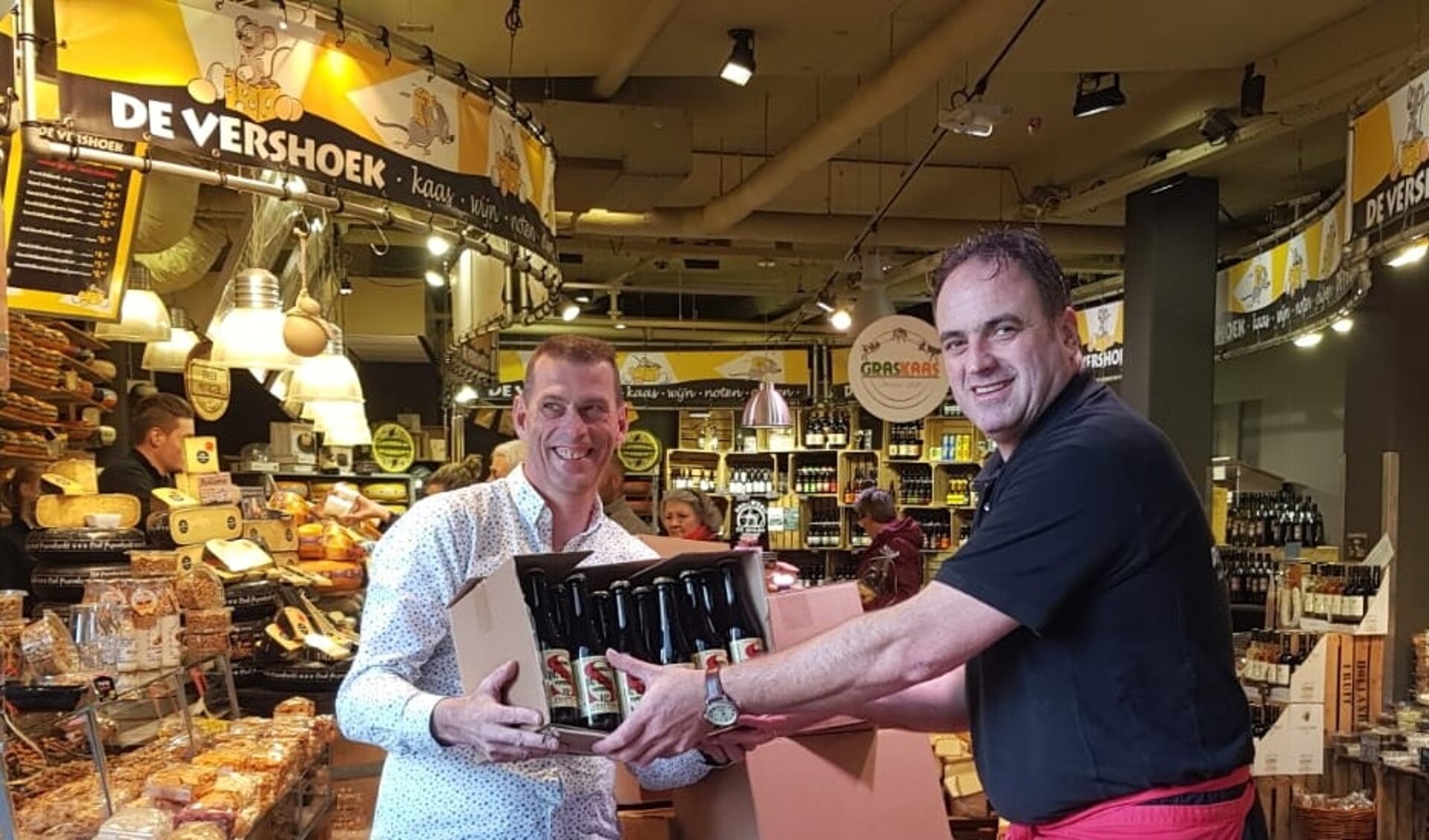 • Sjaak Vennink overhandigt het bier aan Gerrit-Jan Verstoep.