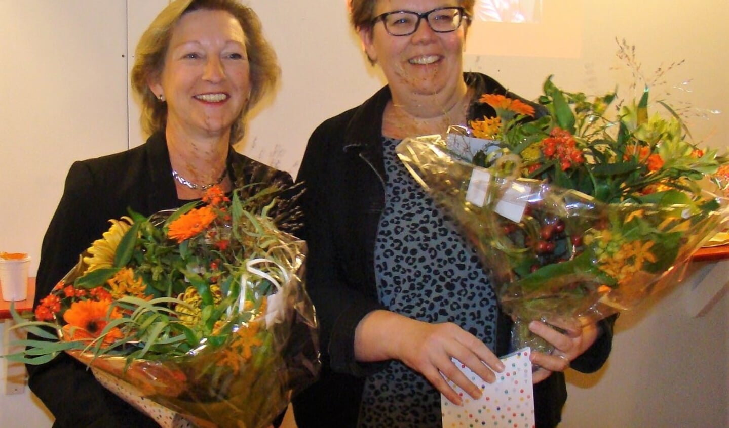 Maddy Pameijer (links) en Erica van Kalkeren (rechts) worden in de bloemetjes gezet als afscheid nemende bestuursleden. Zij wachten nu op nieuwe kandidaten om de taken defintief over te dragen.