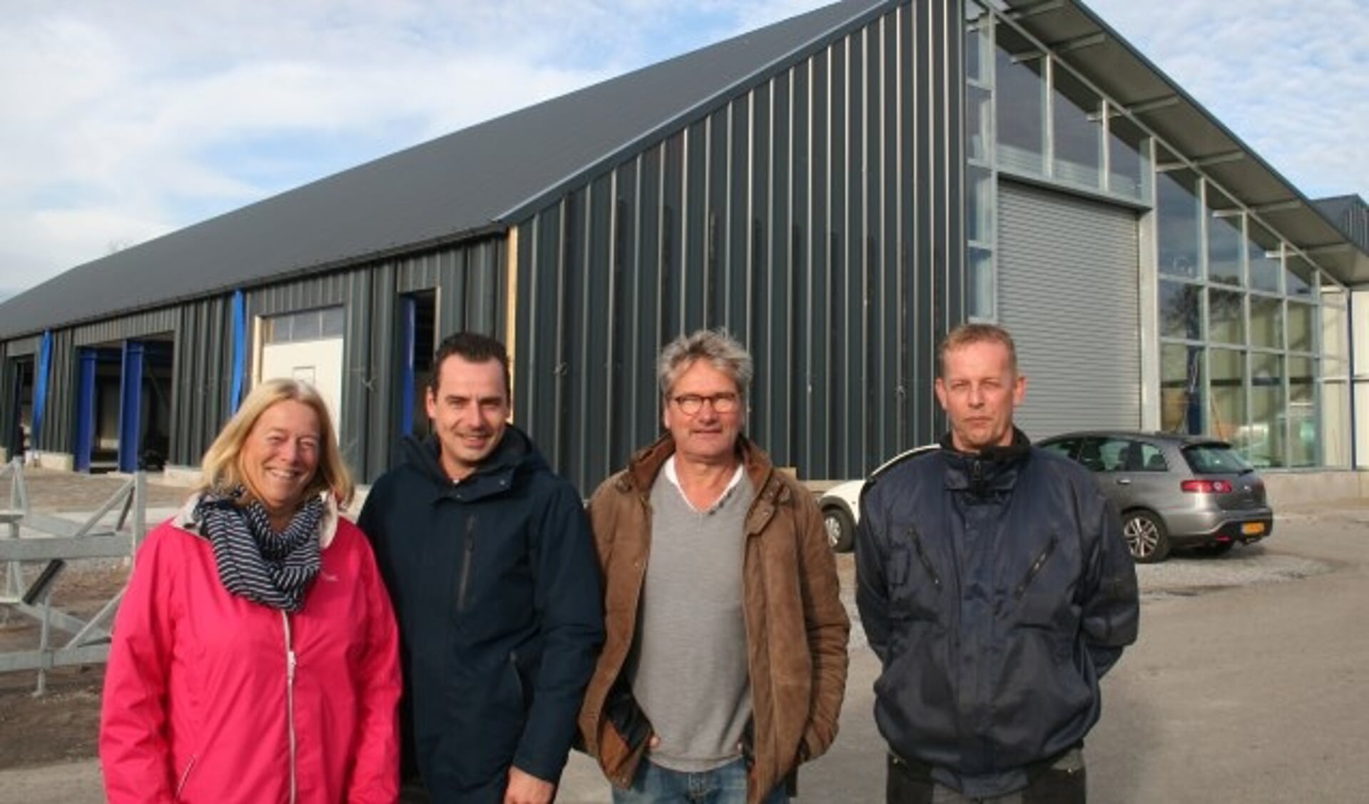 Mieke Kromwijk, Daniël Dekker, Jan Kromwijk en Jan-Erik Reuvekamp voor de herbouwde botenloodsen van de jachthaven. (Foto: Rinus Verweij)