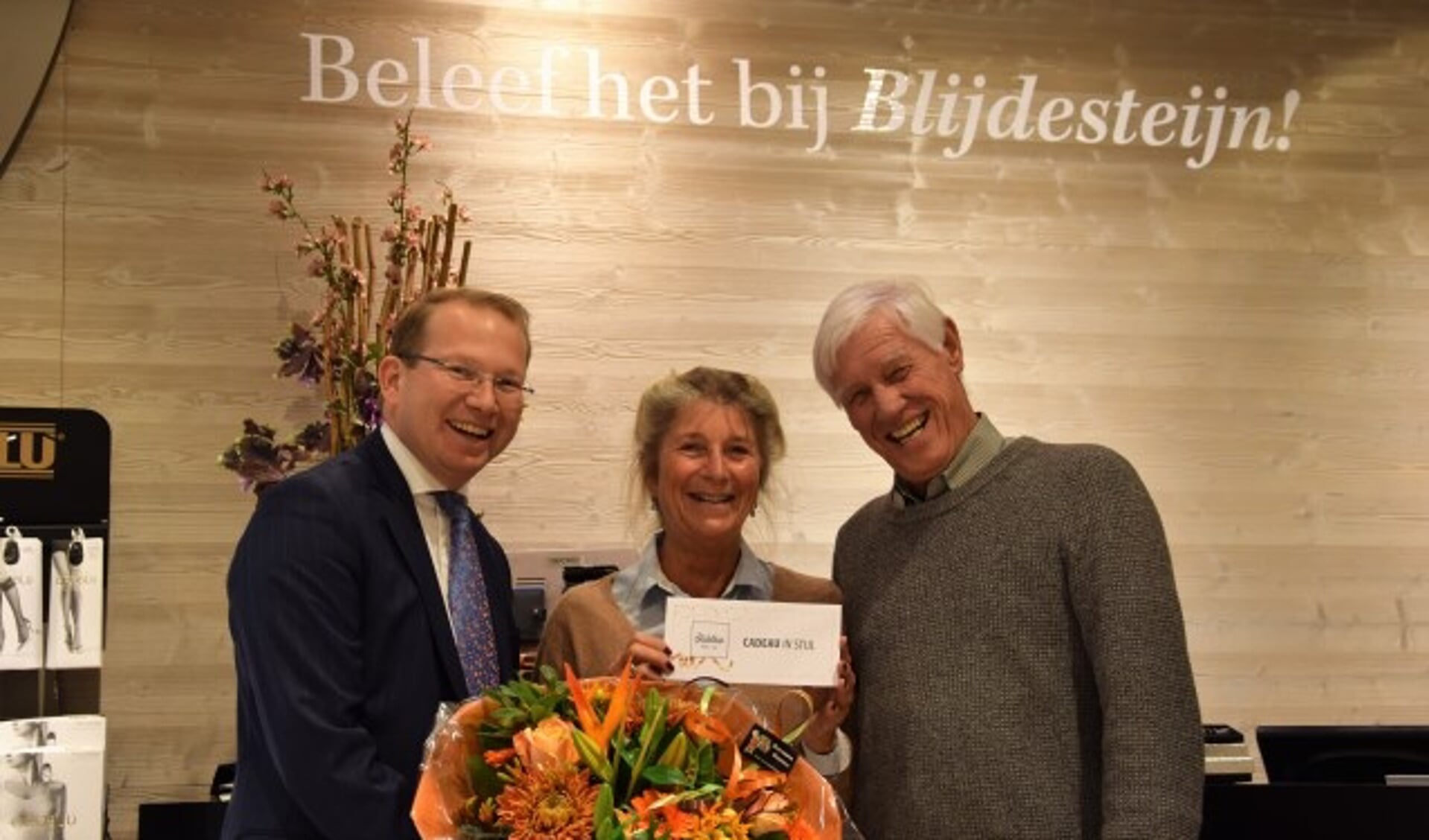 Bram van Blijdesteijn (links) overhandigt de cadeaucheque ter waarde van 500 euro aan de blije winnaars van de FlipPas maandprijs  Claudette Kruseman en Jos van Veen. (Foto: Janet Kooren)