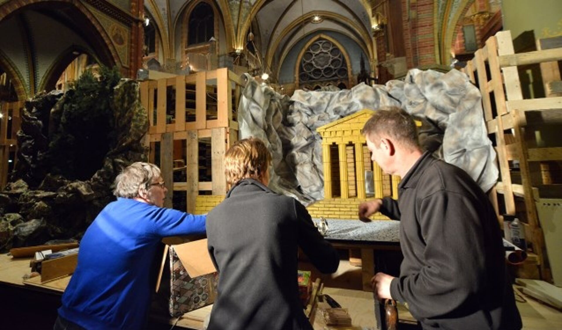 Miranda Hoogenboom, Elly de Wit en Kees van Vliet zijn druk doende met het opbouwen van de kerststalletjes. (Foto: Paul van den Dungen)