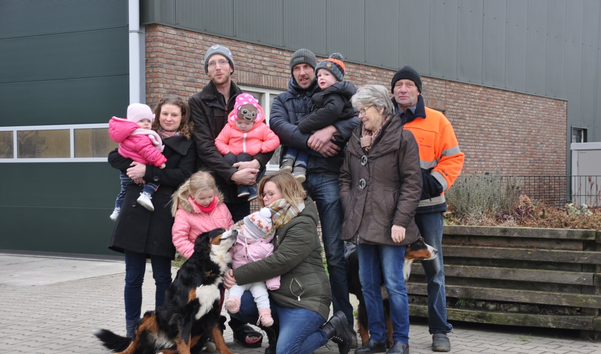 Drie generaties familie Van Winden voor hun schuur vol zonnepanelen. Ze gaan leveren aan Altena Nieuwe Energie.