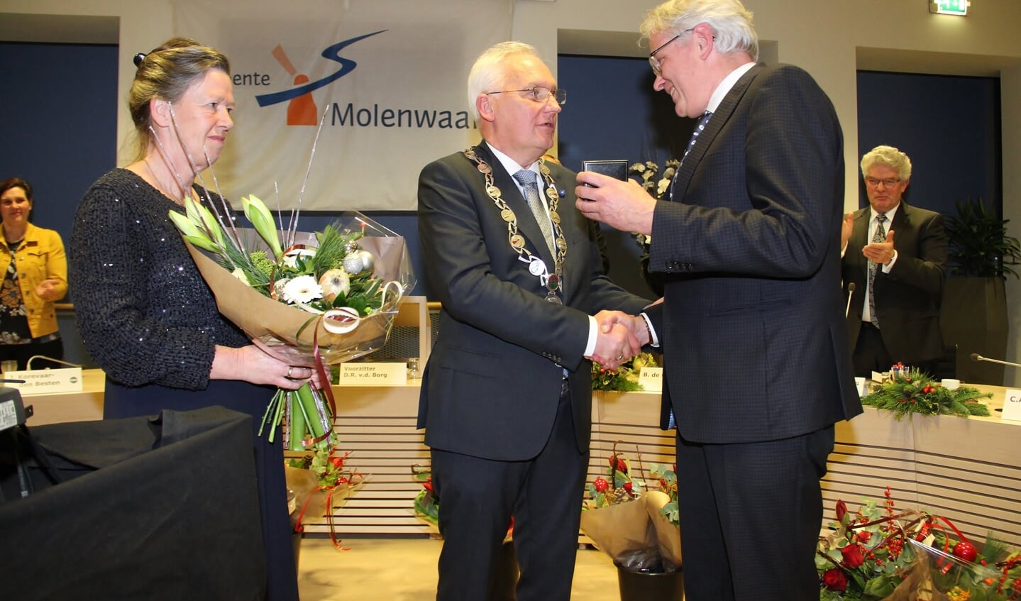 • Wethouder Kees Boender overhandigt de erepenning aan Dirk van der Borg. Links de echtgenote van Van der Borg.