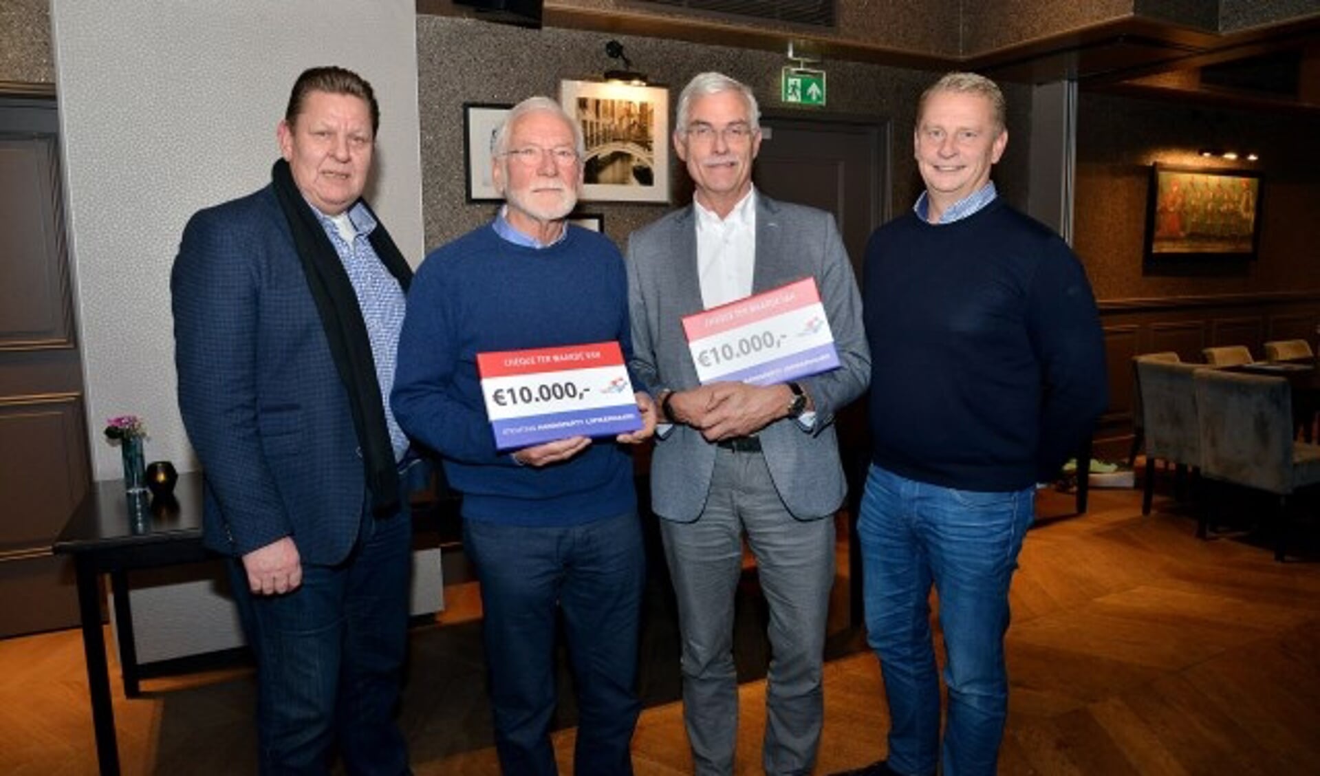 Gert Kraan (links) en Berry van den IJssel (rechts) overhandigden namens de Haringparty Lopikerwaard aan de Hospices van Oudewater en IJsselstein elk een cheque van 10.000 euro. (Foto: Paul van den Dungen)