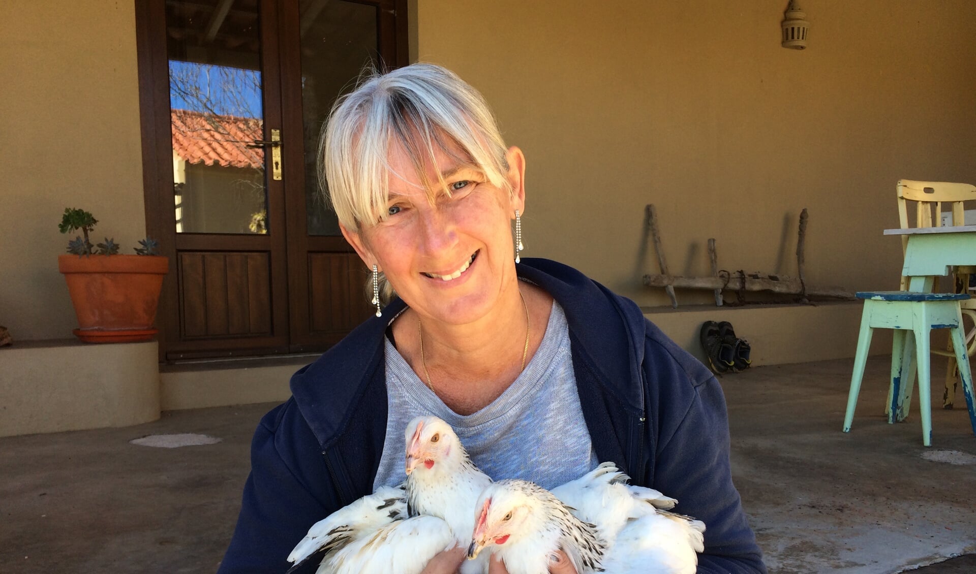 • Anja met haar kippen, bij haar tijdelijke huis in Portugal. De kippen zijn inmiddels gedoneerd aan een plaatselijk café.