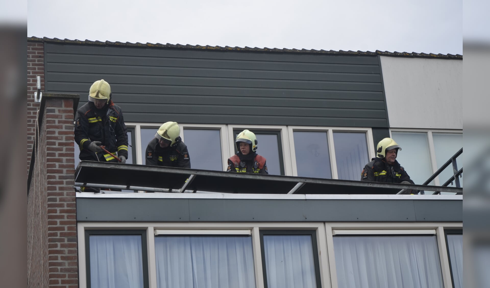 • Brandweerlieden bezig met het verwijderen van de balustrade. 