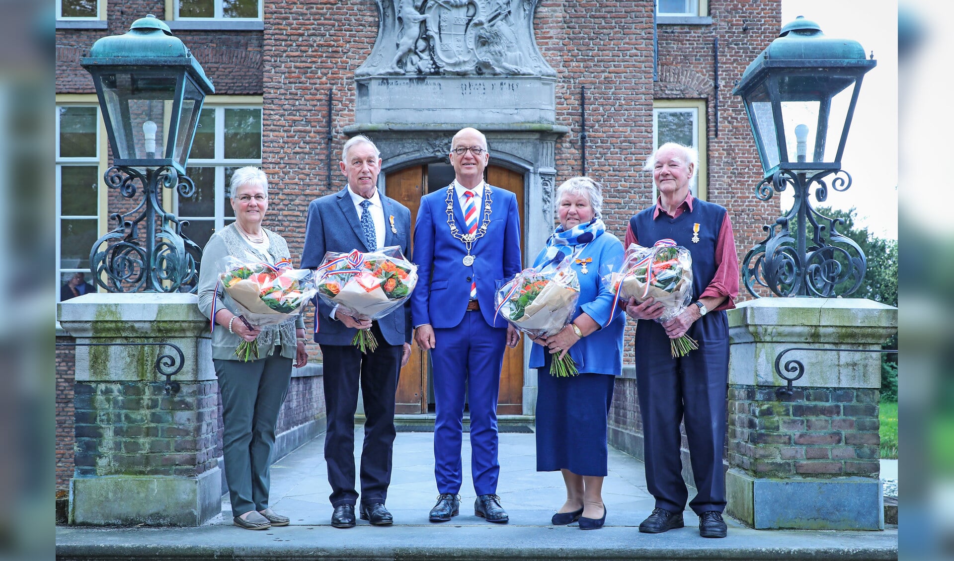 • De vier gedecoreerden samen met burgemeester Harry de Vries.