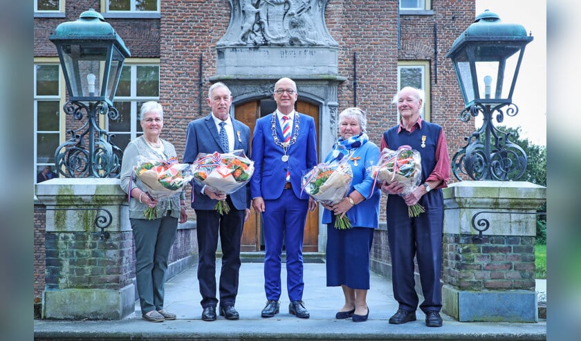 • De vier gedecoreerden samen met burgemeester Harry de Vries.