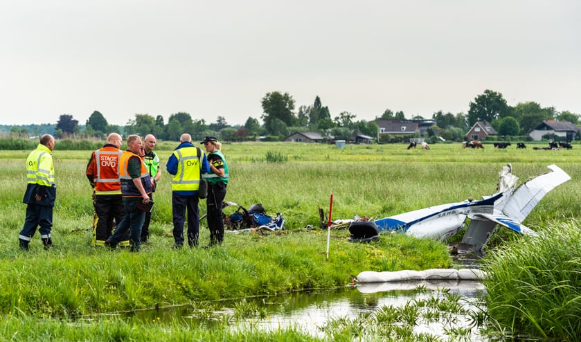 • Hulpverleners en een onderzoeksteam zijn druk bezig op de plaats van het neergestorte sportvliegtuig.