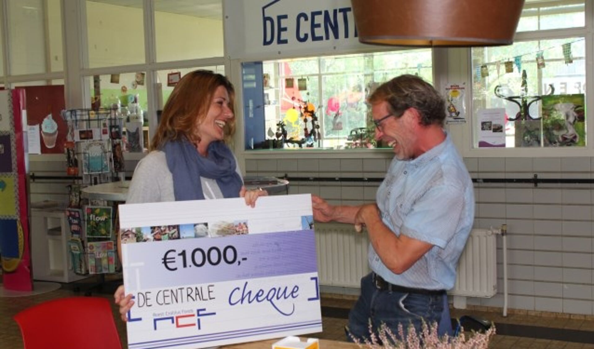 Henk de Ruiter wordt door Ketlin van Esschoten verrast met duizend euro van het Roest Crollius Fonds. 