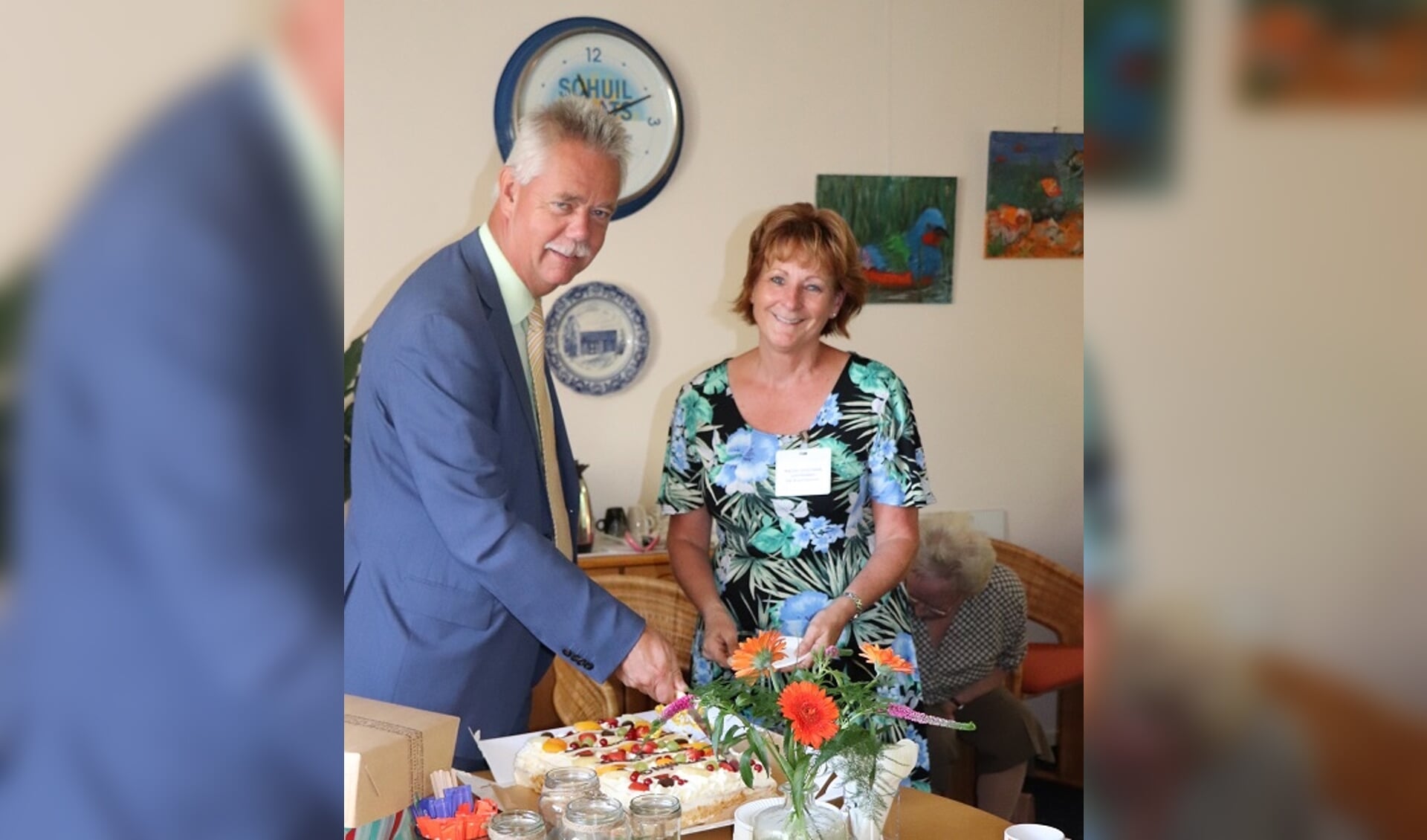 • Wethouder Johan van Everdingen en coördinator Marjan Overbeek snijden de taart aan. 