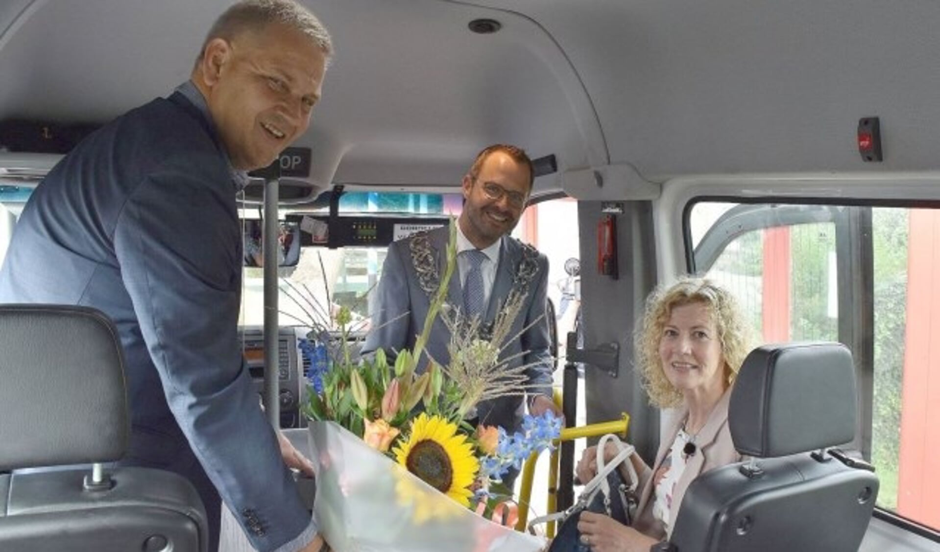 Mevrouw Schoone, die nietsvermoedend de buurtbus 505 nam richting IJsselstein, kreeg als half miljoenste reiziger een bijzonder escorte en bloemen van voorzitter Van de Veen. (Foto: Buurtbusvereniging)