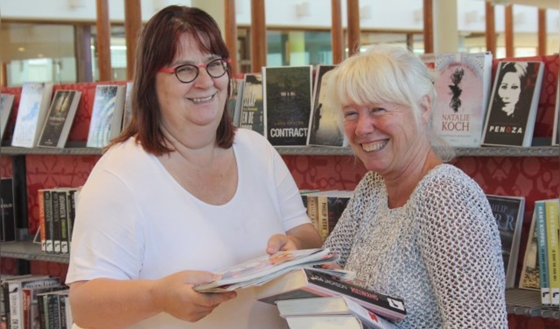 Marianne van Schaik en vrijwilligster Miriam van der Veen zoeken samen boeken uit voor een klant. (Foto: Lysette Verwegen)