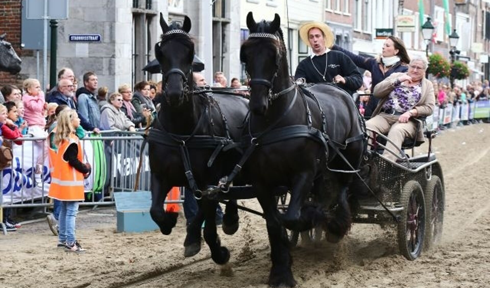 • Arend van den Berg met moeder en dochter en z'n twee Friezen tijdens het ringsteken op een eerdere editie van de Paardenmarkt in Vianen. 