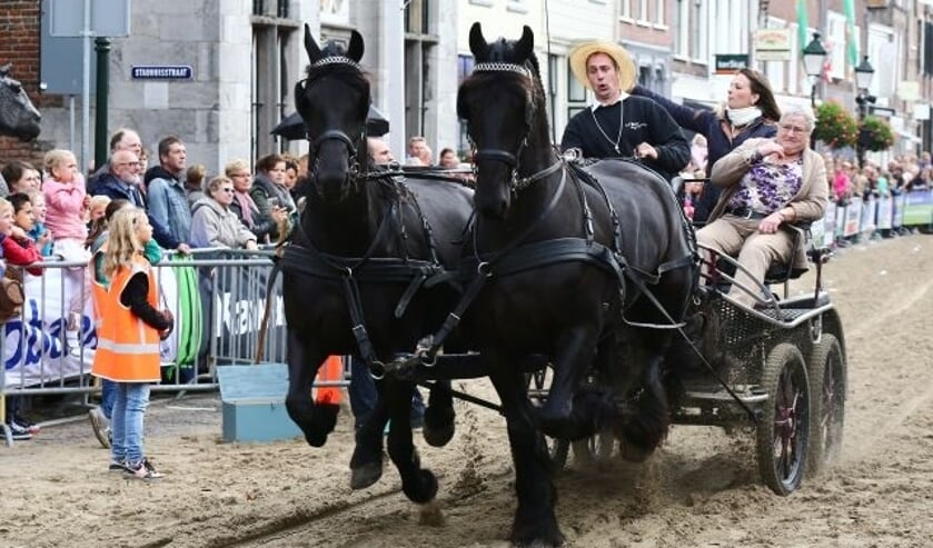 • Arend van den Berg met moeder en dochter en z'n twee Friezen tijdens het ringsteken op een eerdere editie van de Paardenmarkt in Vianen.