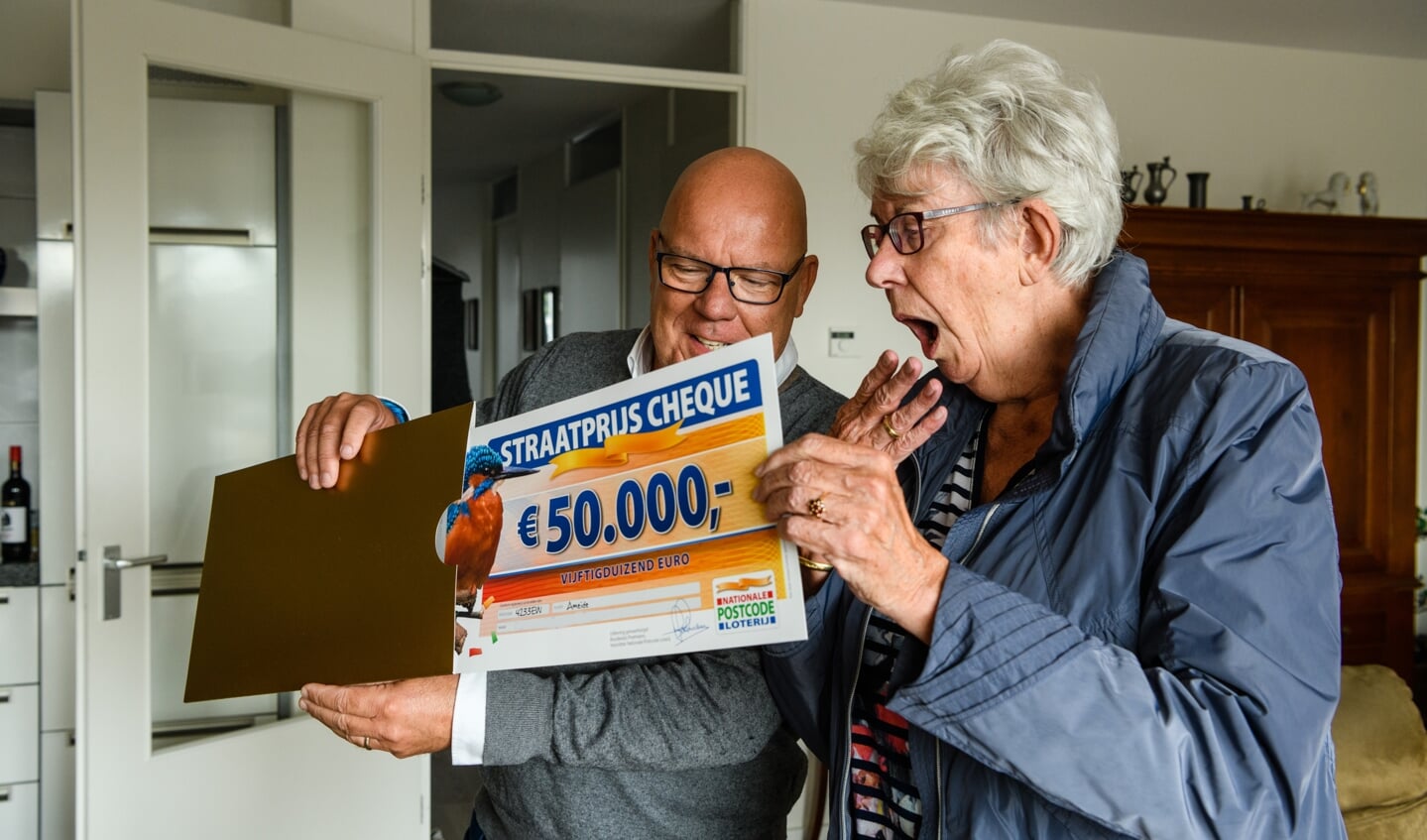 Bep uit Ameide wordt verrast door Postcode Loterij-ambassadeur Gaston Starreveld met de PostcodeStraatprijs-cheque.