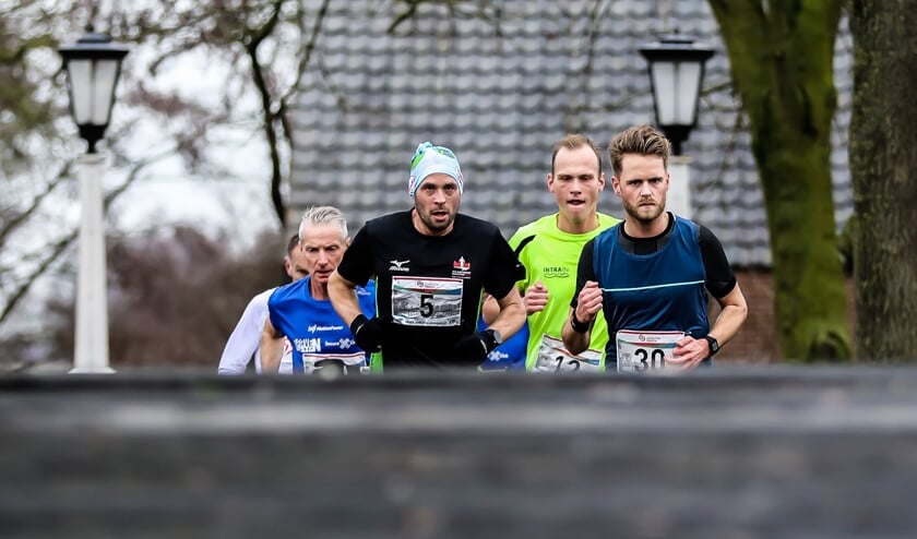 • Een groep 10 km-lopers net achter de kop 'beklimt' de Pinkeveerse Brug.