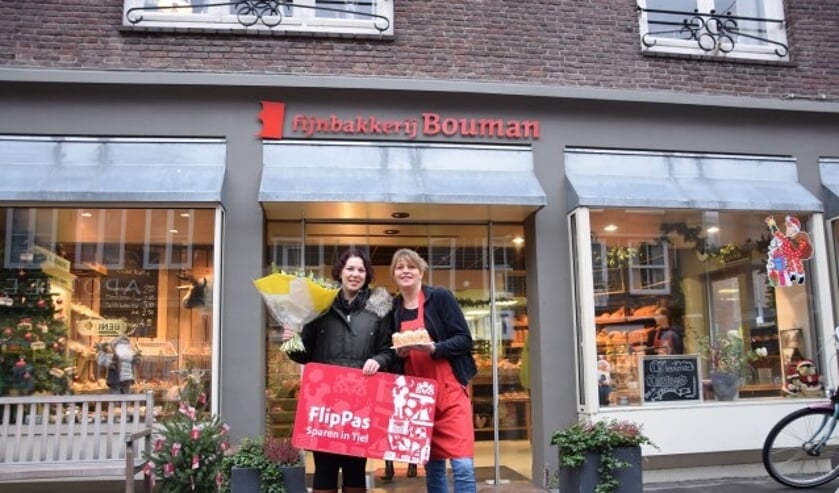 Saskia Tijmen (links) ontvangt van Anika van Mook (Bakkerij Bouman) een heerlijke taart en 100.000 FlipPas-punten. Het boeket bloemen werd aangeboden door Meeuwsen bloemen. (Foto: Janet Kooren)  