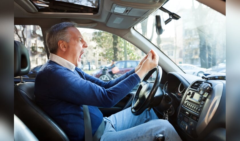 Portrait of an angry driver yelling in his car