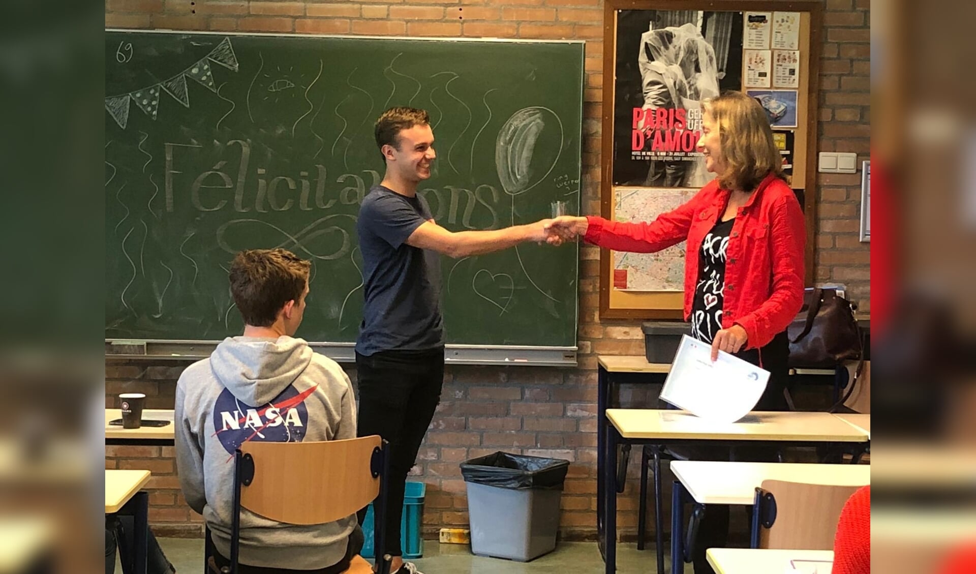 • Docent Hermien Hol overhandigt een DELF-diploma aan een leerling.