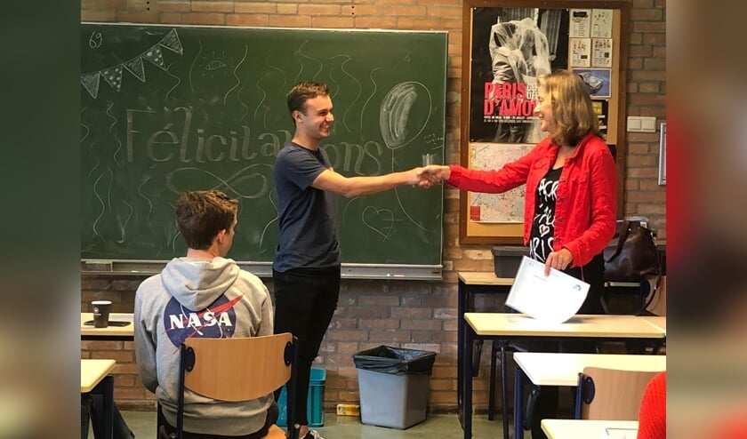 • Docent Hermien Hol overhandigt een DELF-diploma aan een leerling.