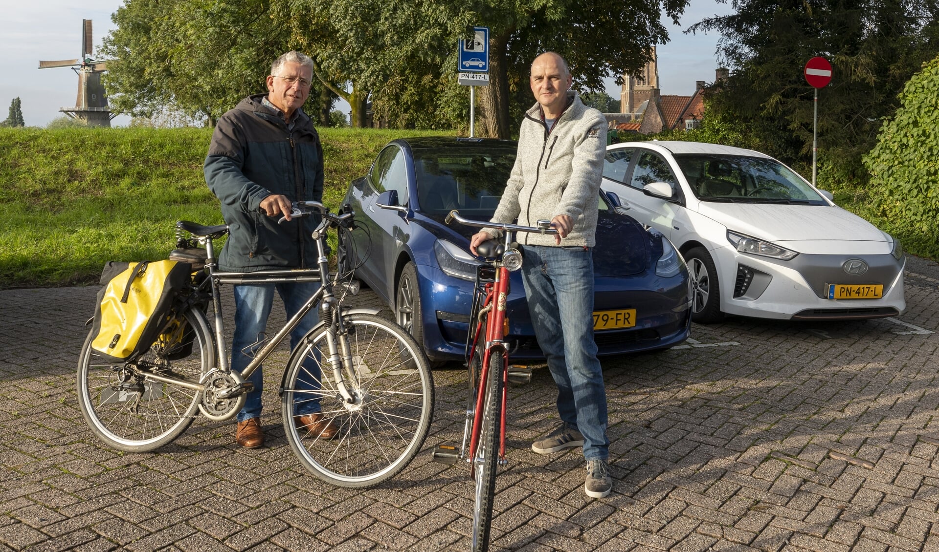 JanDerk Stegeman (rechts) en Goof van Vliet bij de elektrische auto's, die Woudrichemmers samen delen.