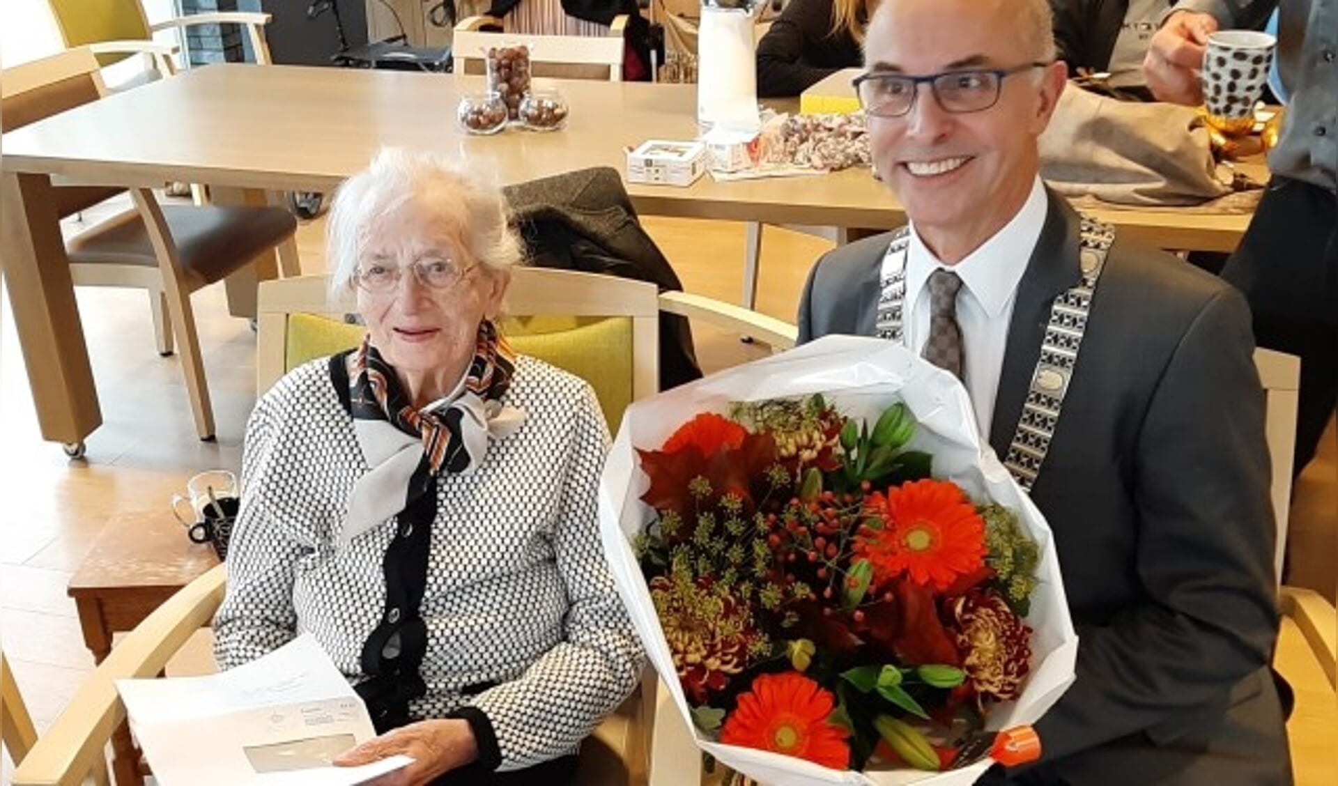 Bloemen in Ewoud uit handen van locoburgemeester Mark Foekema voor de honderdjarige Ans van den Berg, die ook felicitaties ontving van de Koning en Koningin. (Foto: Rinus Verweij)