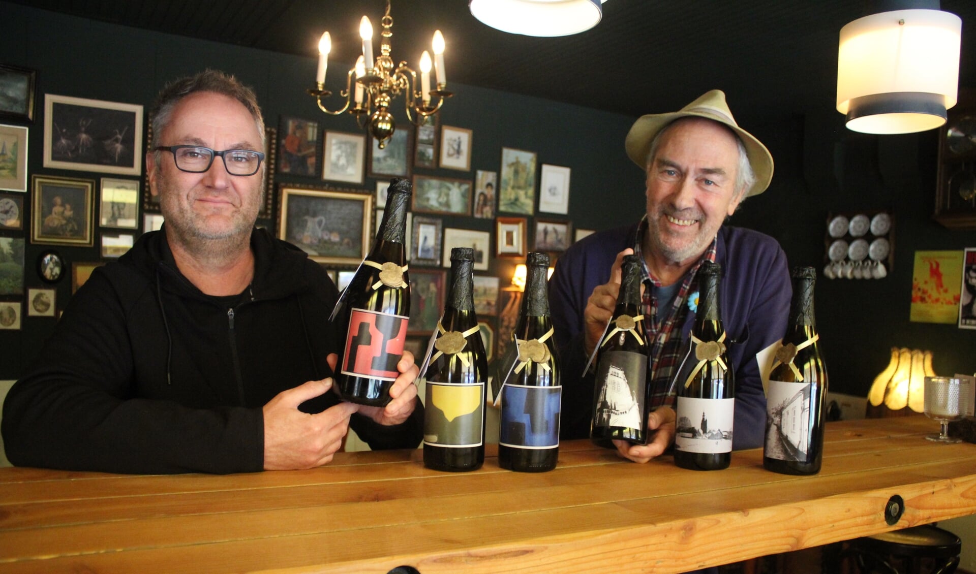 • Kees van de Wal (links) en Piet Krens met hun werk op de flessen.