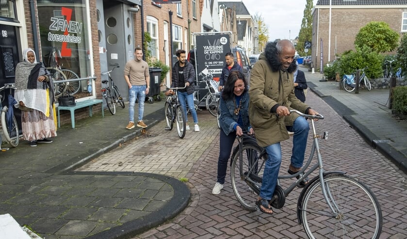 • Erica Jaspers geeft één van de vluchtelingen op de fiets een duwtje.