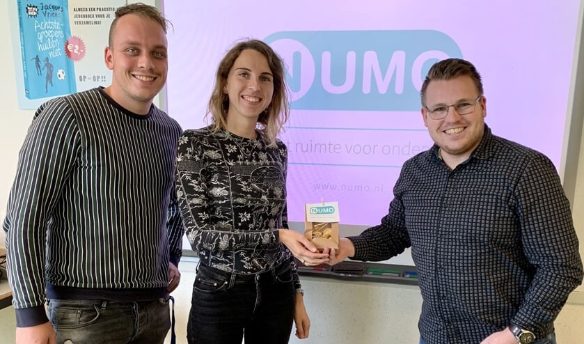 • Docenten Sigrid van Tuijl en Danny van Dijk ontvangen chocolade-Numo’s uit handen van Numo-expert Nico Wagter (r).