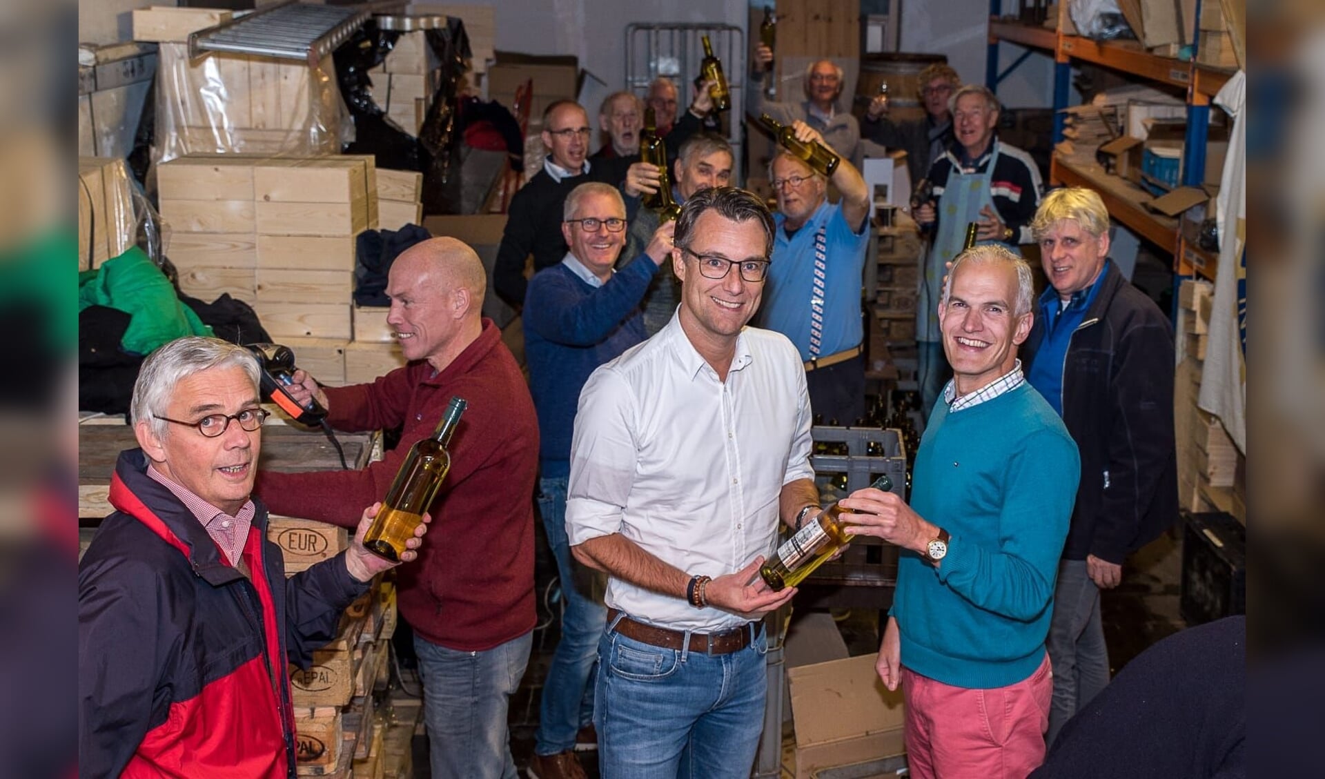 • Maurits Mooij (m) neemt de eerste fles wijn in ontvangst.