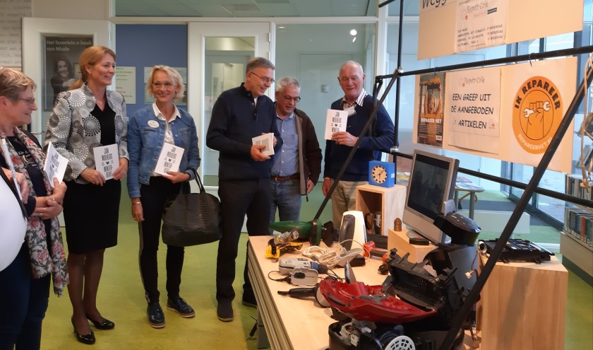 • Wethouder Anita Sørensen (2e van links) bij de kijk- en leestafel in Bibliotheek Ammerzoden.