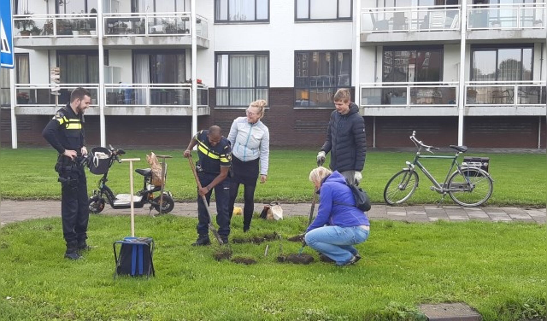 Bij de flats aan De Baan kwam zelfs de politie een handje meehelpen en zette de schop in de grond voor het leuke initiatief van KlimaatNeutraal IJsselstein. (Foto: KNIJ)