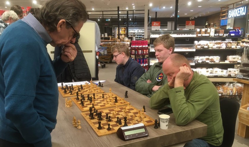 • Wim van Oostrum geeft simultaan aan een drietal borden tegelijkertijd.