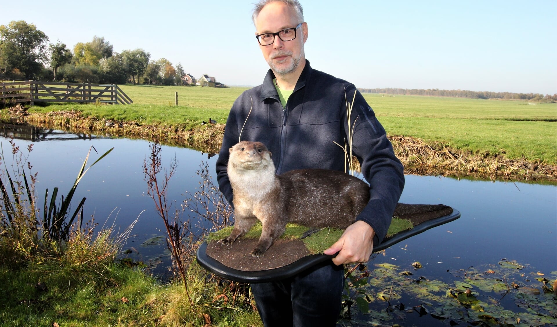 • Hans Blom in de tuin van zijn huis langs de Meije, met in zijn hand de opgezette otter die een plek krijgt in de expositie van het bezoekerscentrum De Veenweiden in Alphen aan de Rijn. 