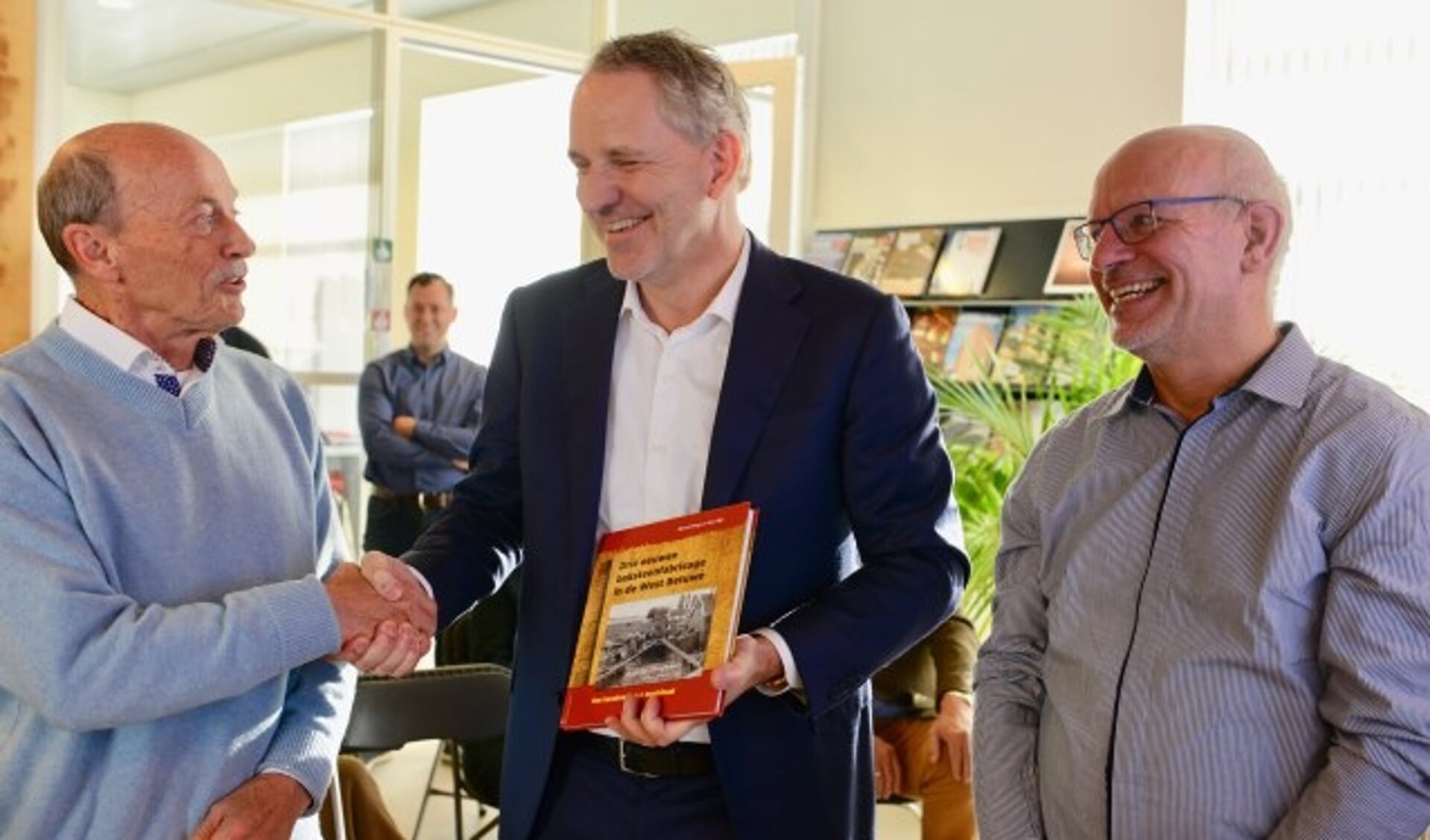 De auteurs overhandigen het eerste boek aan de directeur van de steenfabriek in Haaften (vlnr) Aart Bijl, dhr. Koekoek en Marcel Dings.