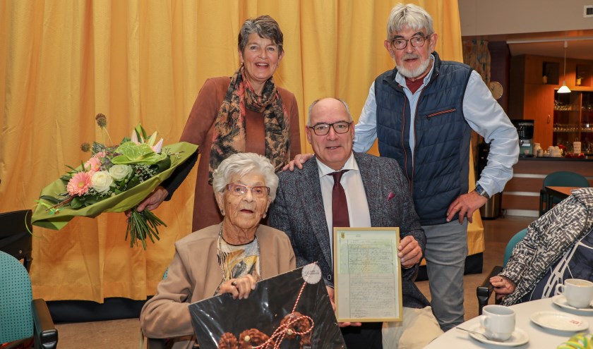 • Lie van Riessen-van Leeuwen samen met burgemeester Henny van Kooten. Daarachter staan de zoon en dochter van Lie.