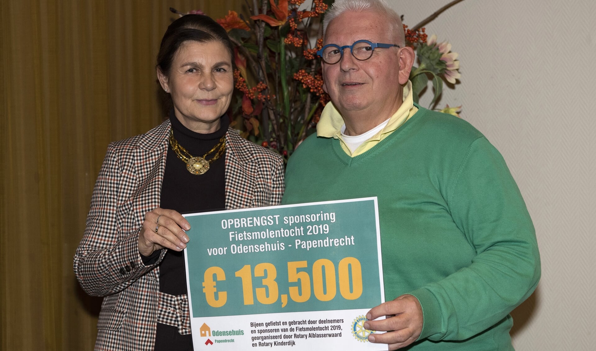 • : Jacqueline van den Bergen overhandigt de cheque aan Piet Bezemer in bijzijn van betrokkenen van Odensehuis en Rotary.