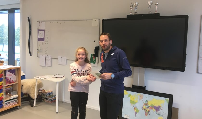 • De meester overhandigt de oorkonde en boekenbon.
