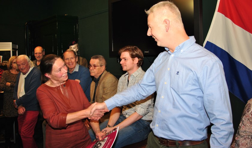 • Paul van den Bighelaar overhandigt de Drielse Vertellingen aan één van de dochters van Antoon Vissers.
