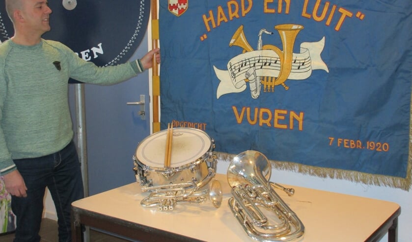 • Johan Zandee bij het vaandel en rad van fortuin van Brassband Harp en Luit in dorpshuis de Koels te Vuren.