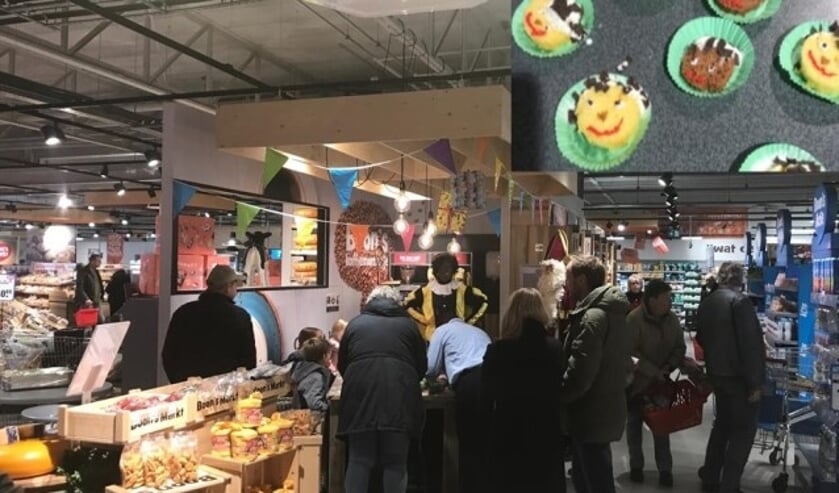 Klanten en kinderen zijn cake aan het versieren met Sint en zijn Pieten.