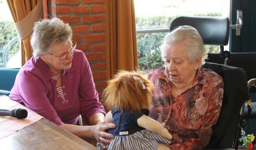 Nanda van Toorn biedt mevrouw Schumacher de Music Doll aan. (foto: Zorgcentra De Betuwe)  