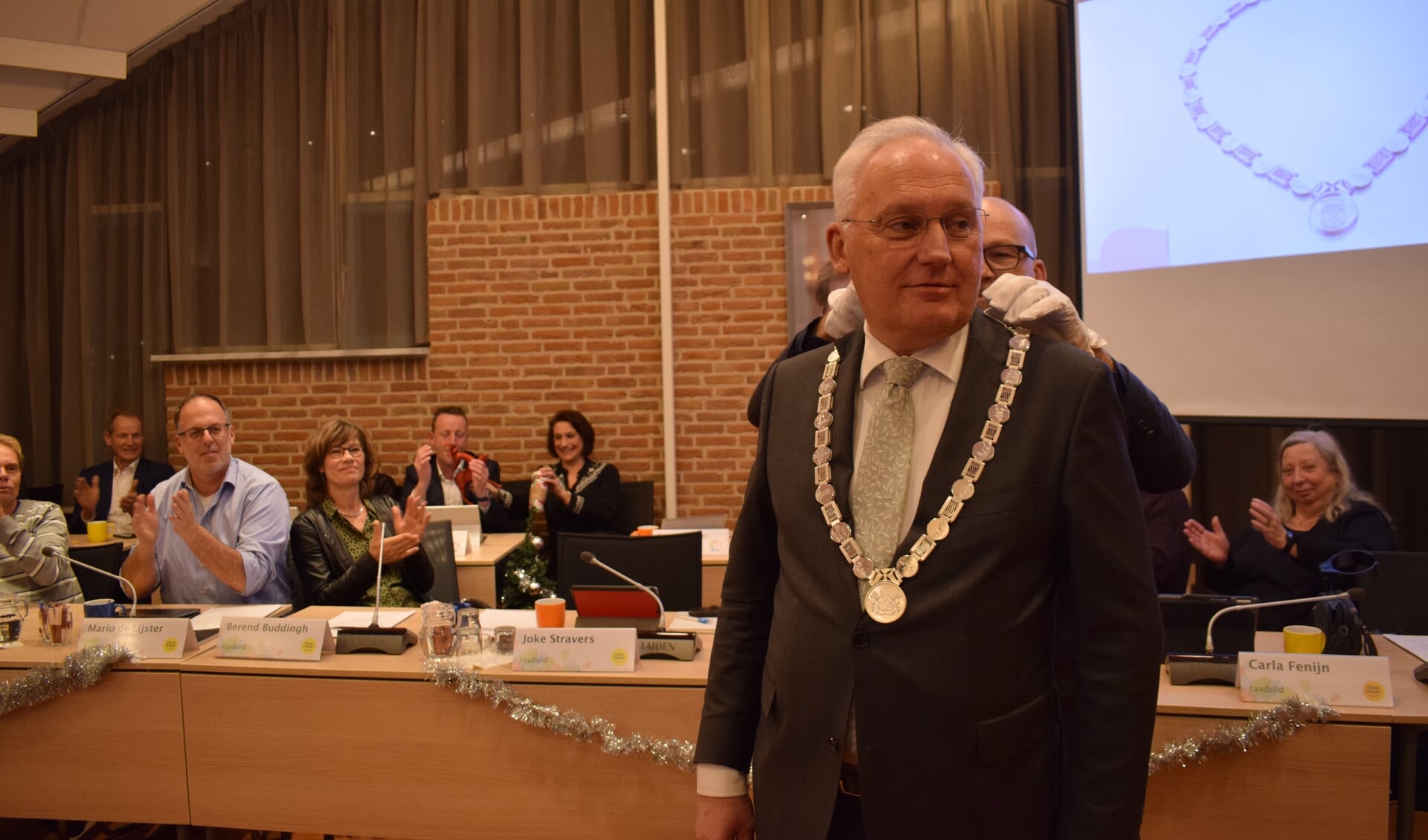 • Burgemeester Dirk van der Borg krijgt de nieuwe ambtsketen omgehangen.