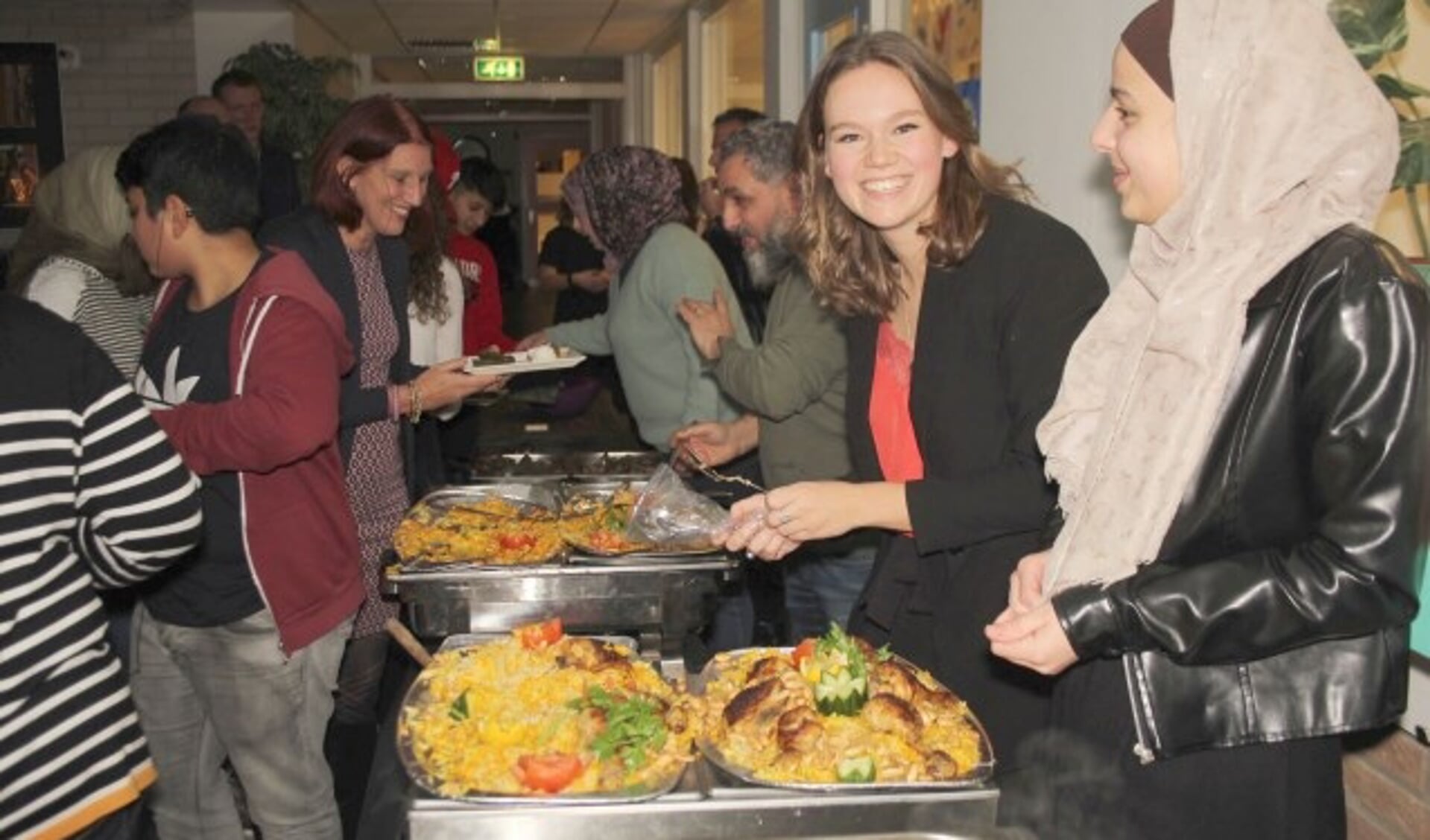 Marlieke van Schalkwijk kreeg bij het serveren van het diner spontaan hulp van Rayan, een van de gasten. (Foto: Lysette Verwegen)