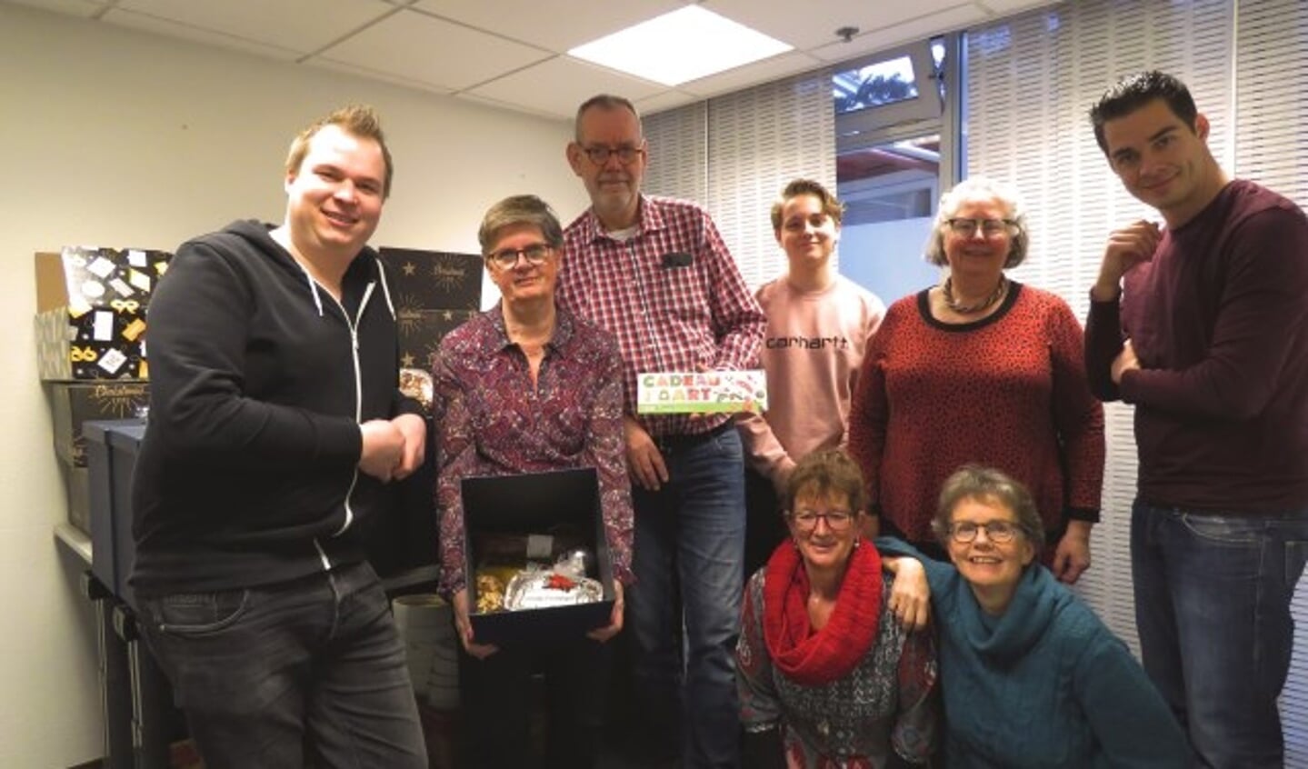 Cornelis Dolderman (links) en Ben Breedveld (rechts) overhandigen de kerstpakketten aan medewerkers van Voedselbank Montfoort.