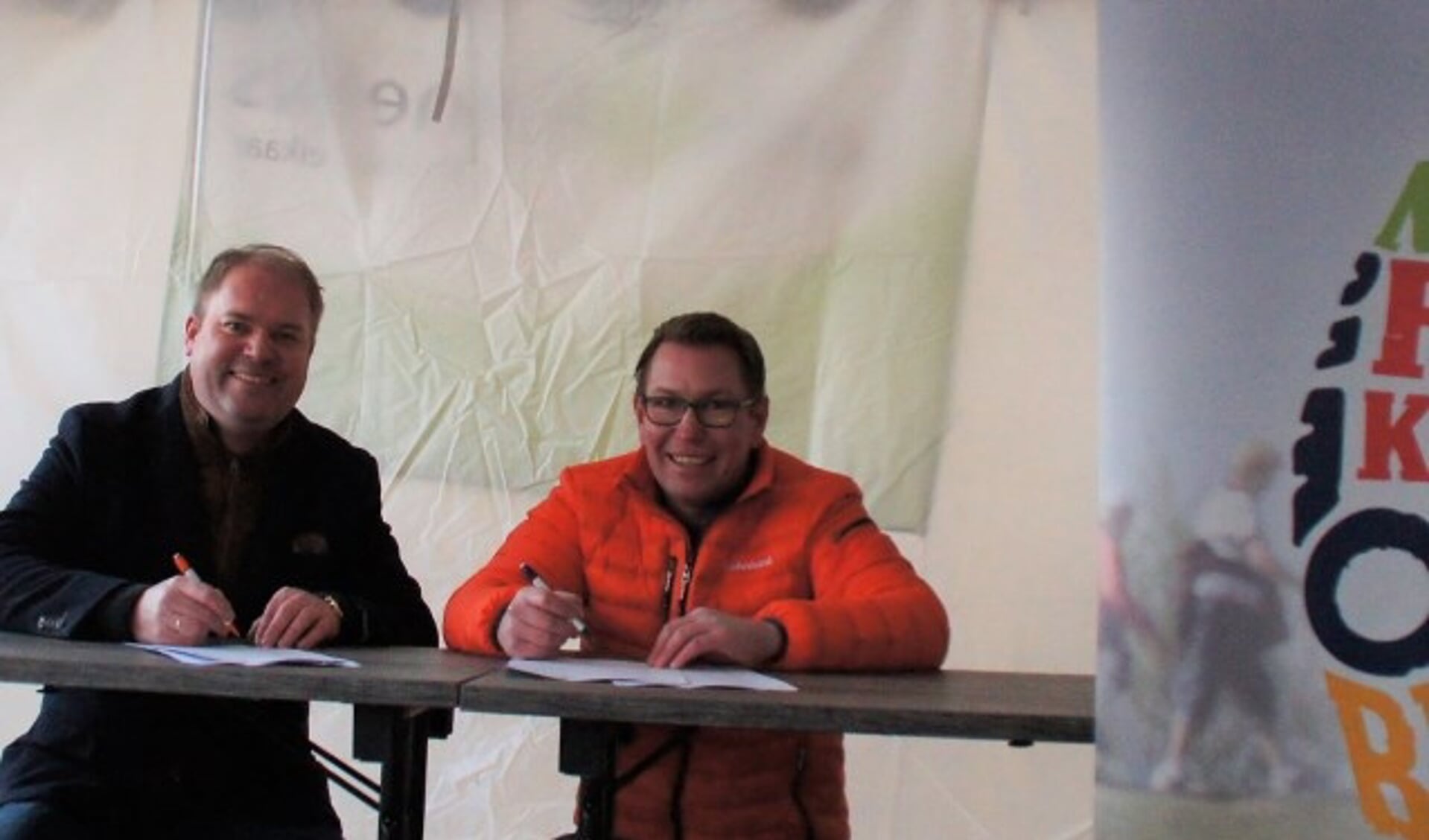 Hans van Kranenburg, voorzitter van de Stichtiing Nationale Rode Kruis Bloesemtocht, en Remco Boer, directeur Particulieren en Private Banking van Rabobank West Betuwe, ondertekenen de nieuwe overeenkomst.