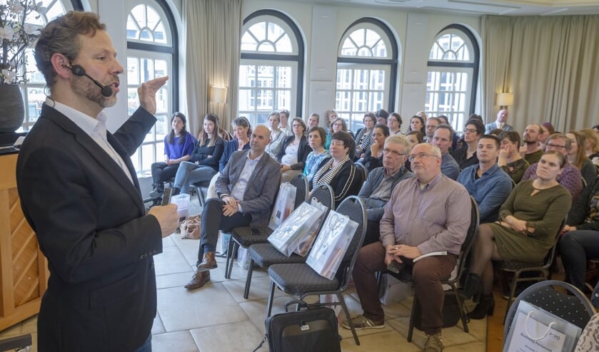 • Ben Tiggelaar voor de zaal met PCPO-medewerkers.