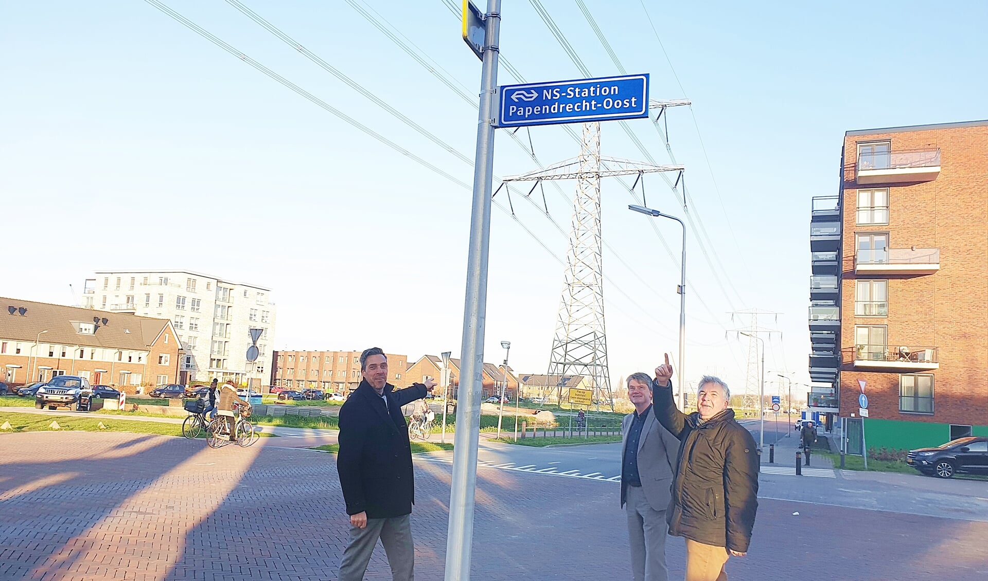 • Wethouder De Ruijter (rechts) en burgemeester Moerkerke (links) bij het nieuwe bord nabij het treinstation.
